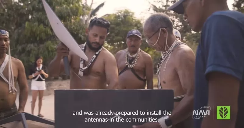 a group of men wearing necklaces and holding a large white object - Amazon Tribe Faces Addiction to Prn and Social Media